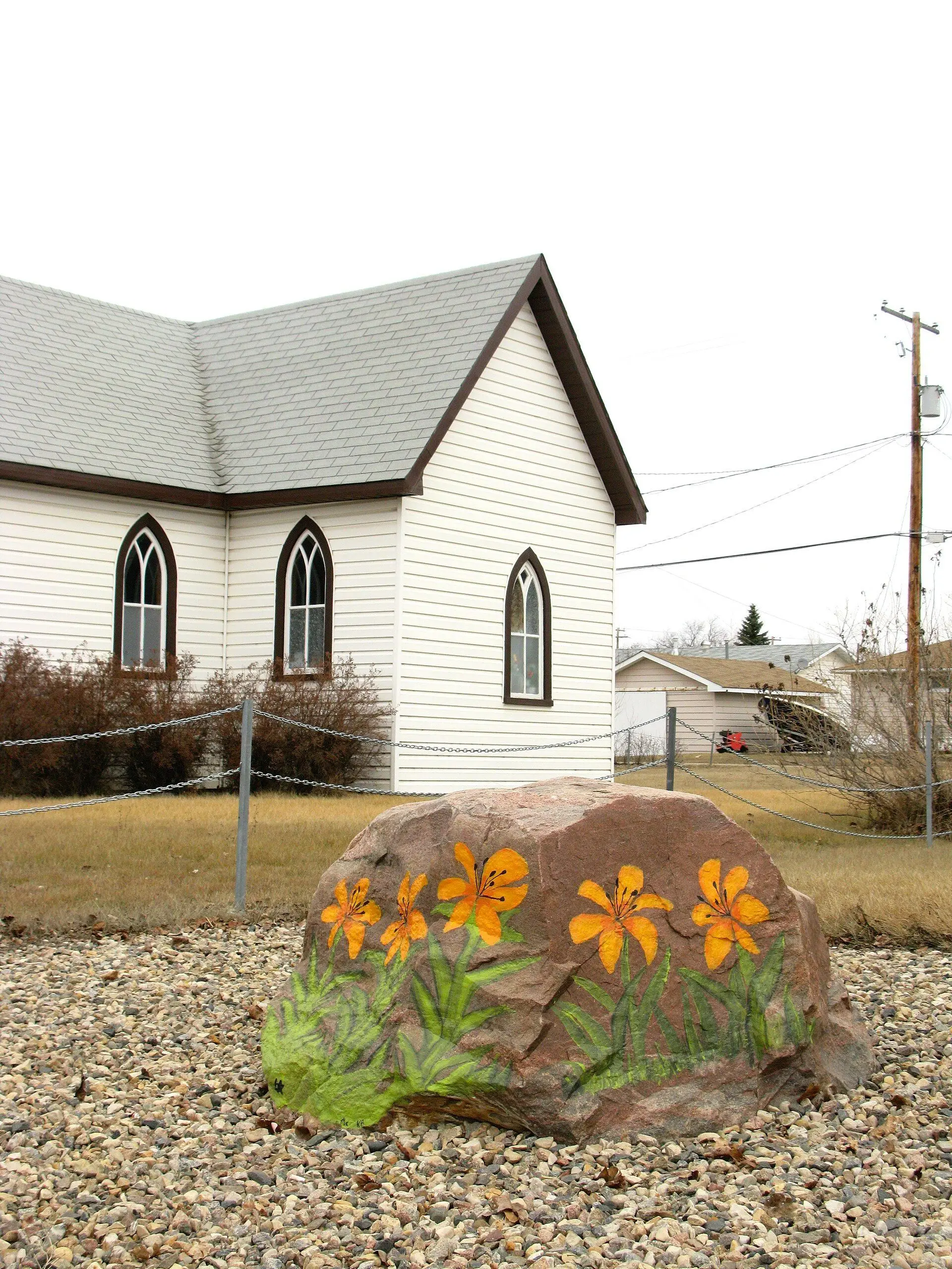 Painted lily rock in front of a small white church