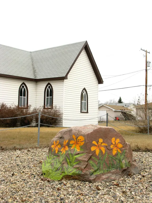 Painted lily rock in front of a small white church